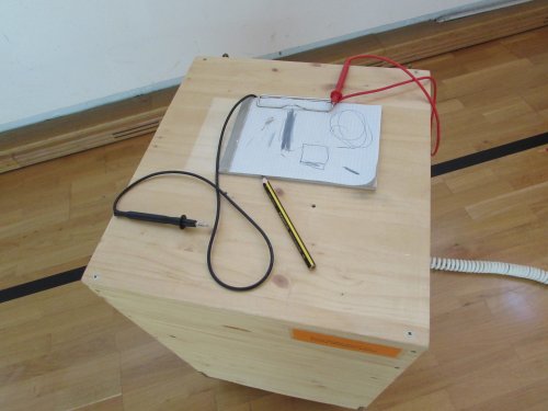 Holzbox mit Kabeln und Zeichnung auf Boden