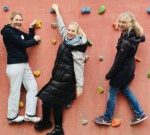 Fünf Leute klettern gemeinsam an einer Wand