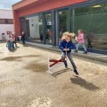 Kind beim Spielen vor einem Schulgebäude