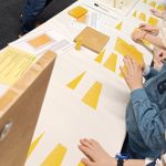 Kinder basteln Bienenwachskerzen an einem Tisch