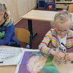 Zwei Kinder puzzeln an einem Schreibtisch im Klassenzimmer