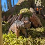 Spielzeugbär im Wald auf moosbewachsenem Boden