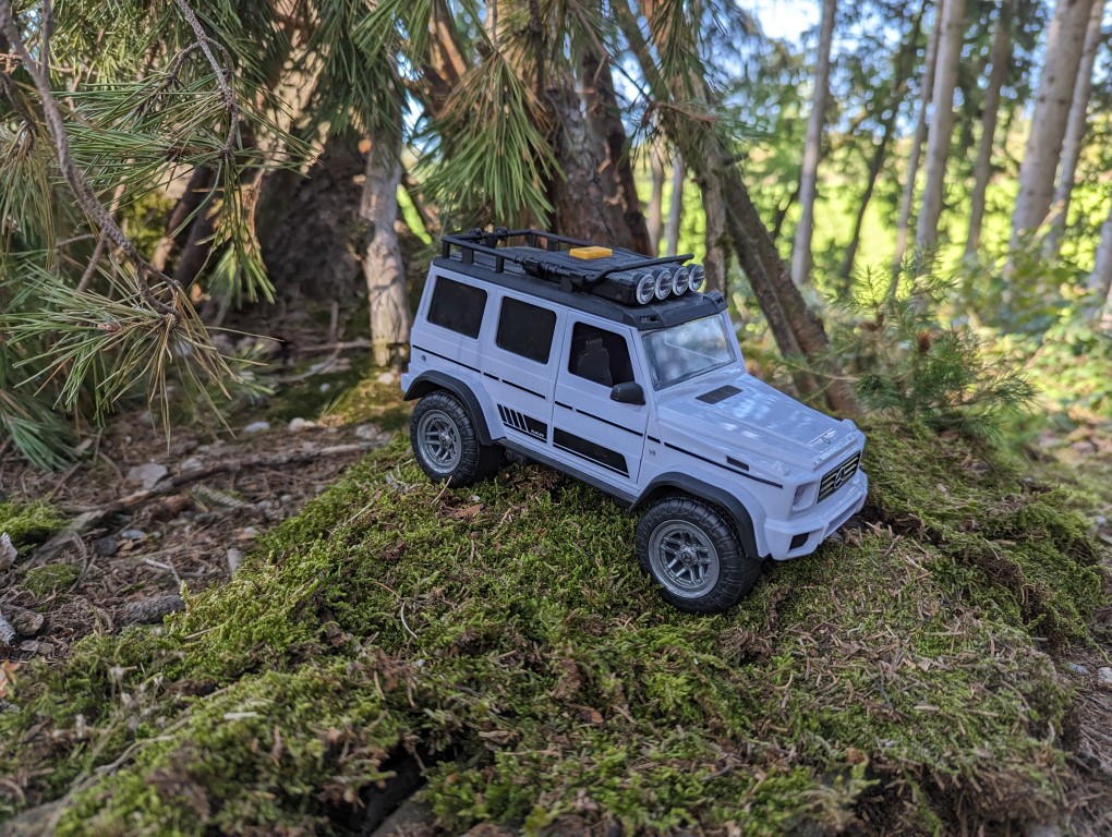 Spielzeugauto im Wald auf moosbedecktem Untergrund