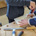 Personen führen gemeinsames DIY-Projekt mit Werkzeugen durch
