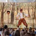 Mann in Theateraufführung mit Kindern im Publikum