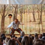 Theateraufführung für Kinder mit Waldkulisse und Publikum
