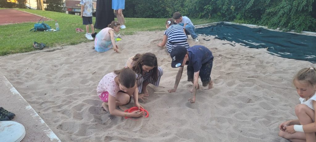 Kinder spielen gemeinsam im Sandkasten im Freien