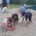 Kinder spielen gemeinsam im Sandkasten im Freien