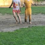 Zwei Kinder spielen fröhlich im schlammigen Garten