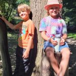 Zwei Kinder spielen fröhlich im Wald.