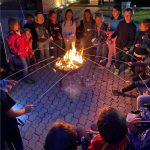 Kinder genießen Lagerfeuerabend mit Marshmallows draußen