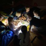 Kinder spielen zusammen im abgedunkelten Raum.