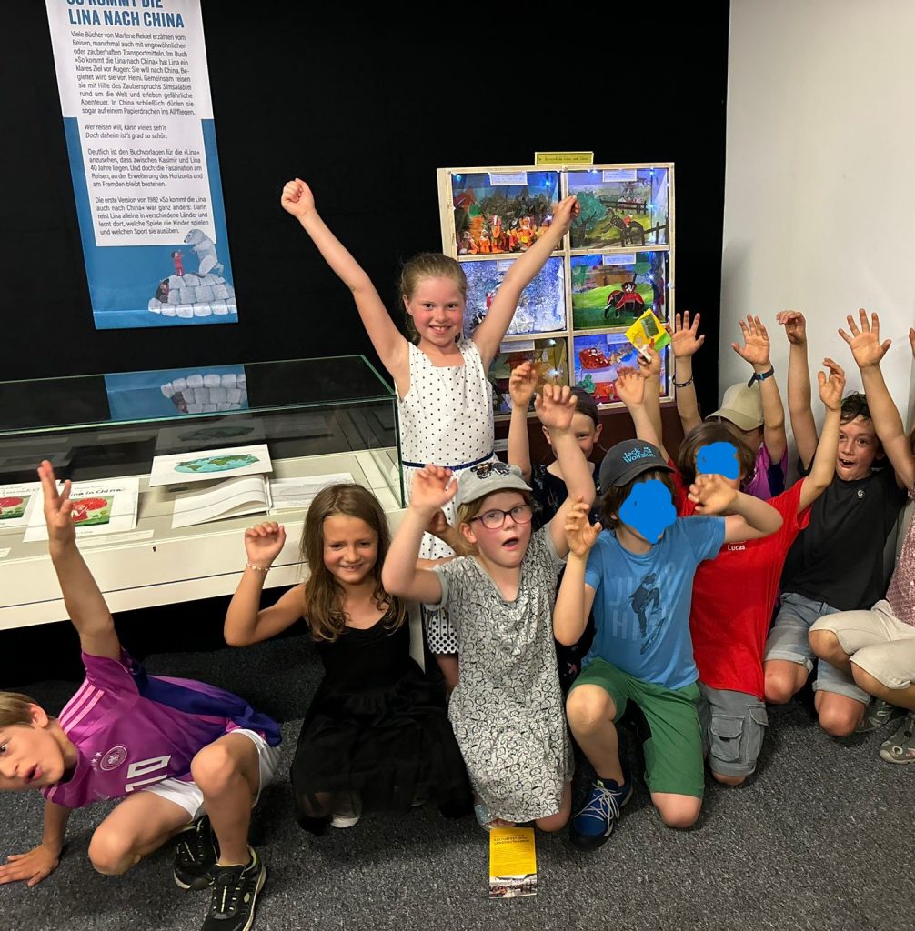 Kinder feiern fröhlich in einem Ausstellungsraum