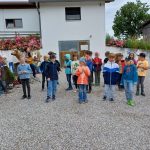 Kinder spielen draußen vor einem Haus zusammen