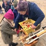 Kinder helfen bei der Apfelernte mit Maschine