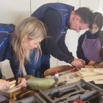 Familie beim gemeinsamen Basteln mit Holz zuhause