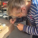 Mädchen schnitzt Holzprojekt mit Konzentration und Geschicklichkeit