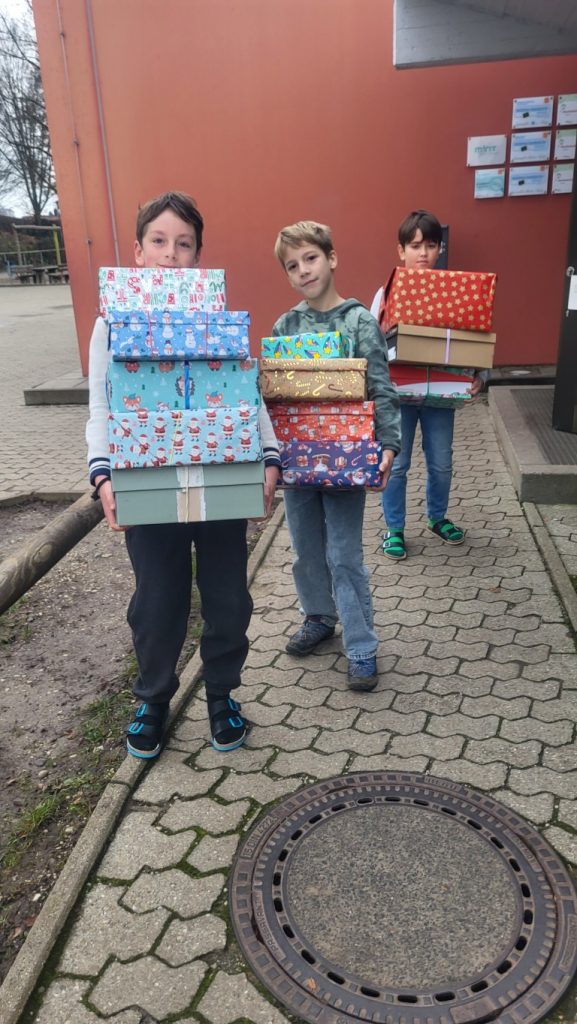 Kinder tragen Geschenke hinaus