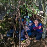 Kinder in selbstgebauter Waldhütte