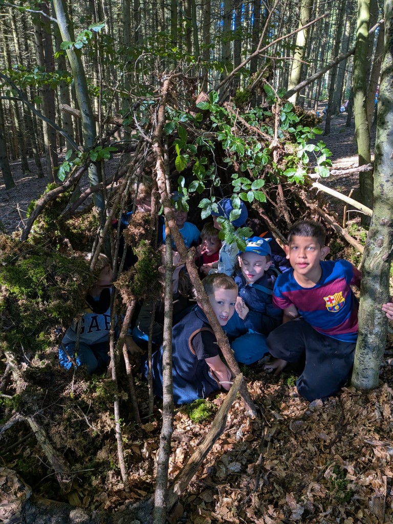 Kinder in selbstgebauter Waldhütte